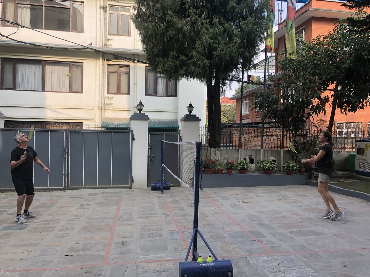 Two guests playing a game of badminton on the residence courtyard