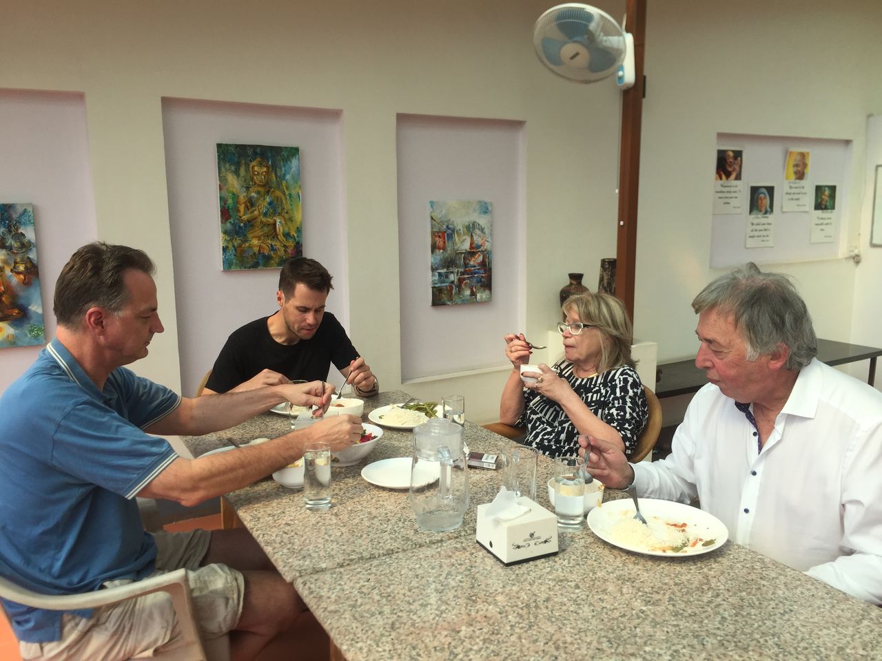 Four people enjoying breakfast together at the residence dining table