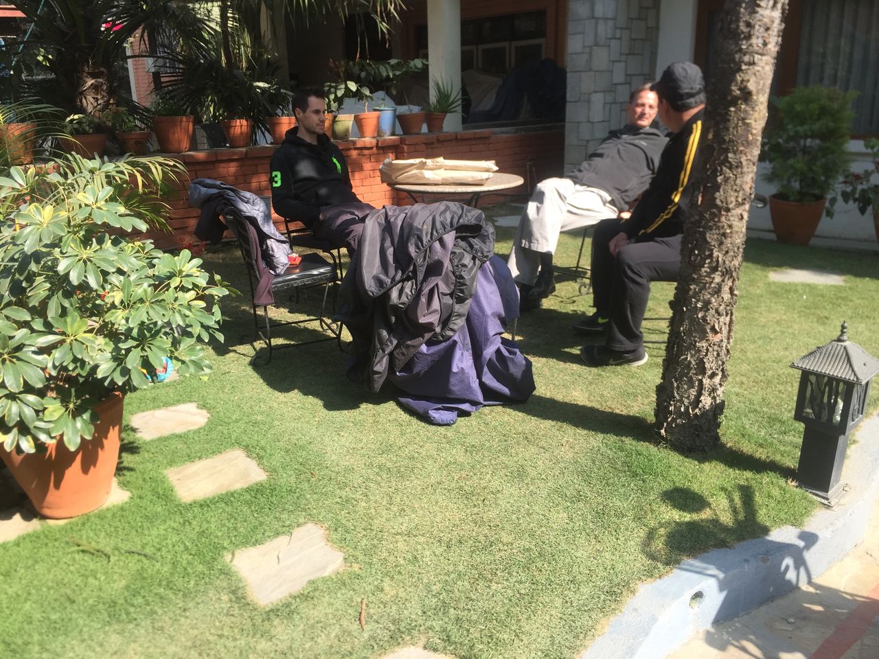 Guests relaxing on chairs on the garden lawn in the afternoon sun