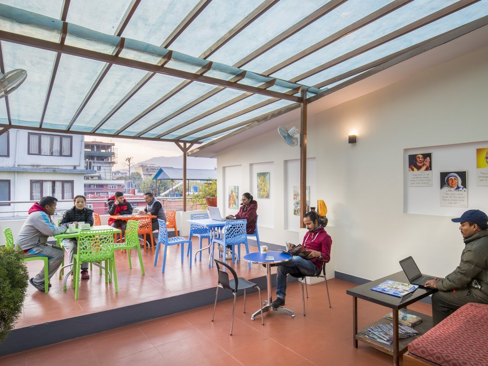 Glass-roofed rooftop terrace with seating, used by guests to work and relax